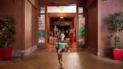 Un niño corriendo con sus juguetes de peluche Chip N Dale, se adelanta a su familia en Disney’s Grand Californian Hotel and Spa.