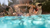 A family of 4 playing in the swimming pool at Disney's Grand Californian Hotel & Spa