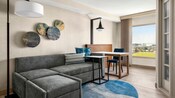 A Family Suite at Anaheim Marriott Suites featuring a couch and a table with chairs and a large window