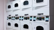 A laundry room with 4 rows of double-stacked washing machines