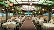 The dining room at the Enchanted Garden, featuring a fountain, glass flower lights and an illuminated pergola style ceiling