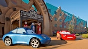 Lightning McQueen and Sally Carrera parked in front of a hotel building Lightning McQueen and Sally Carrera parked in front of a hotel building