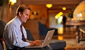 A man works on his laptop in the lobby of Disneys Yacht Club Resort