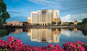 The Gran Destino Tower at Disney’s Coronado Springs Resort, adjacent to the waterfront restaurant Villa del Lago, is reflected on the nearby lake