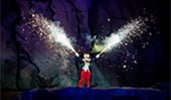Dressed in his familiar tuxedo, Mickey Mouse shoots pyrotechnics from his hands