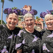 Three women smiling while wearing Mickey ears