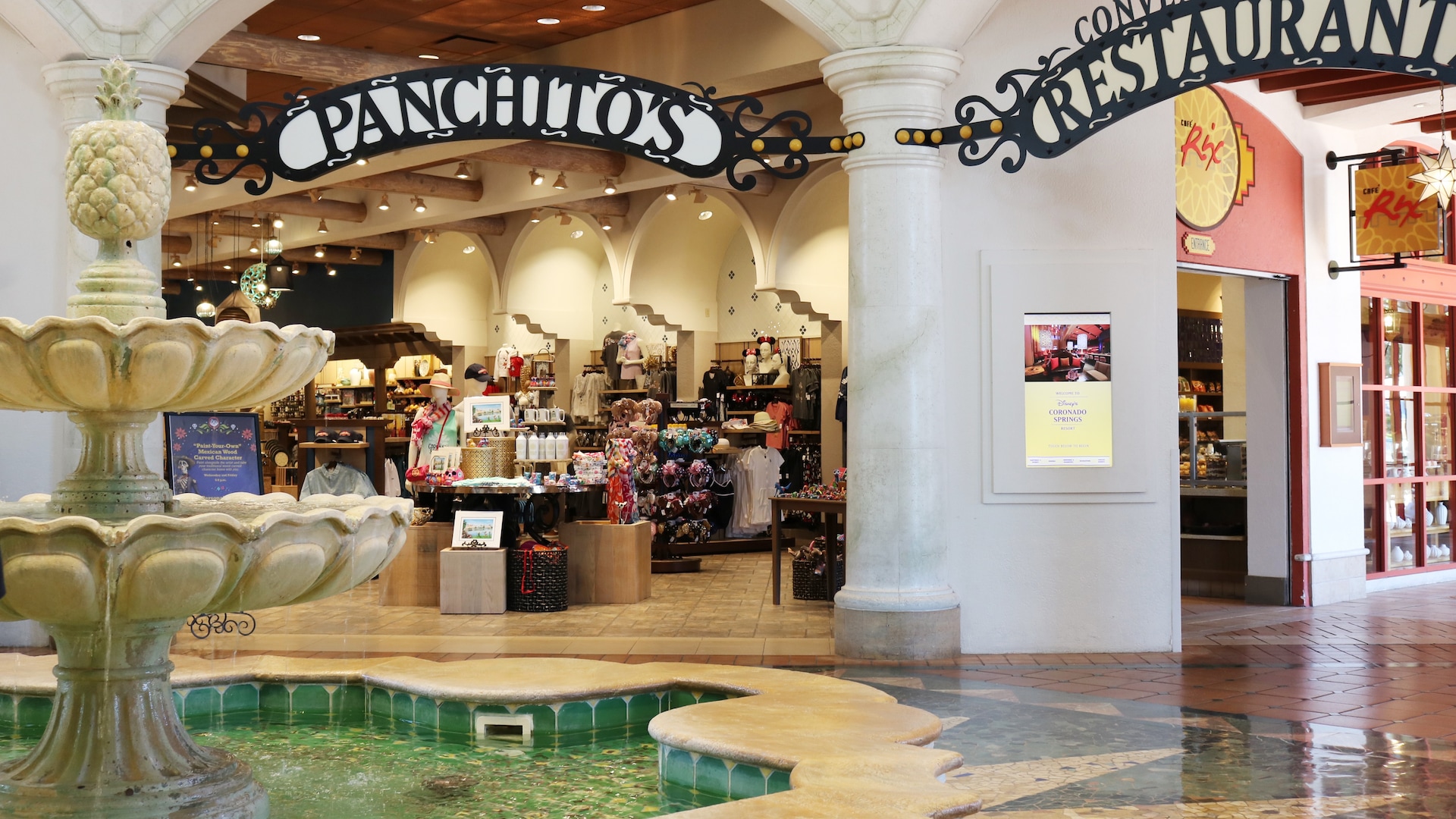 An open air mall setting with a fountain at the entrance of a gift shop called Panchito's