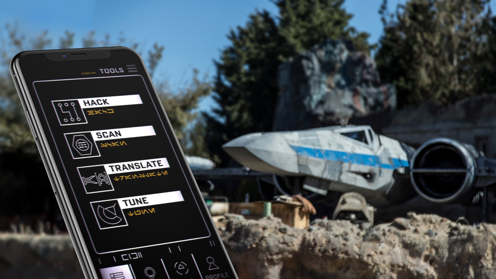 A galactic handheld mobile device displays symbols and characters in Aurebesh, a language used in Star Wars, as a starship looms nearby on the landing pad 