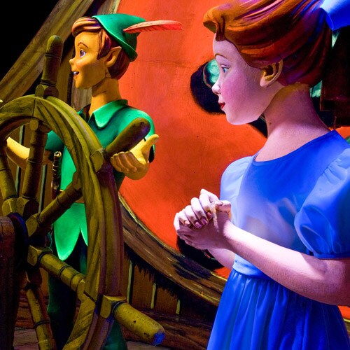 Wendy stands by Peter Pan's side as he steers a ship that takes the Darling children to Neverland