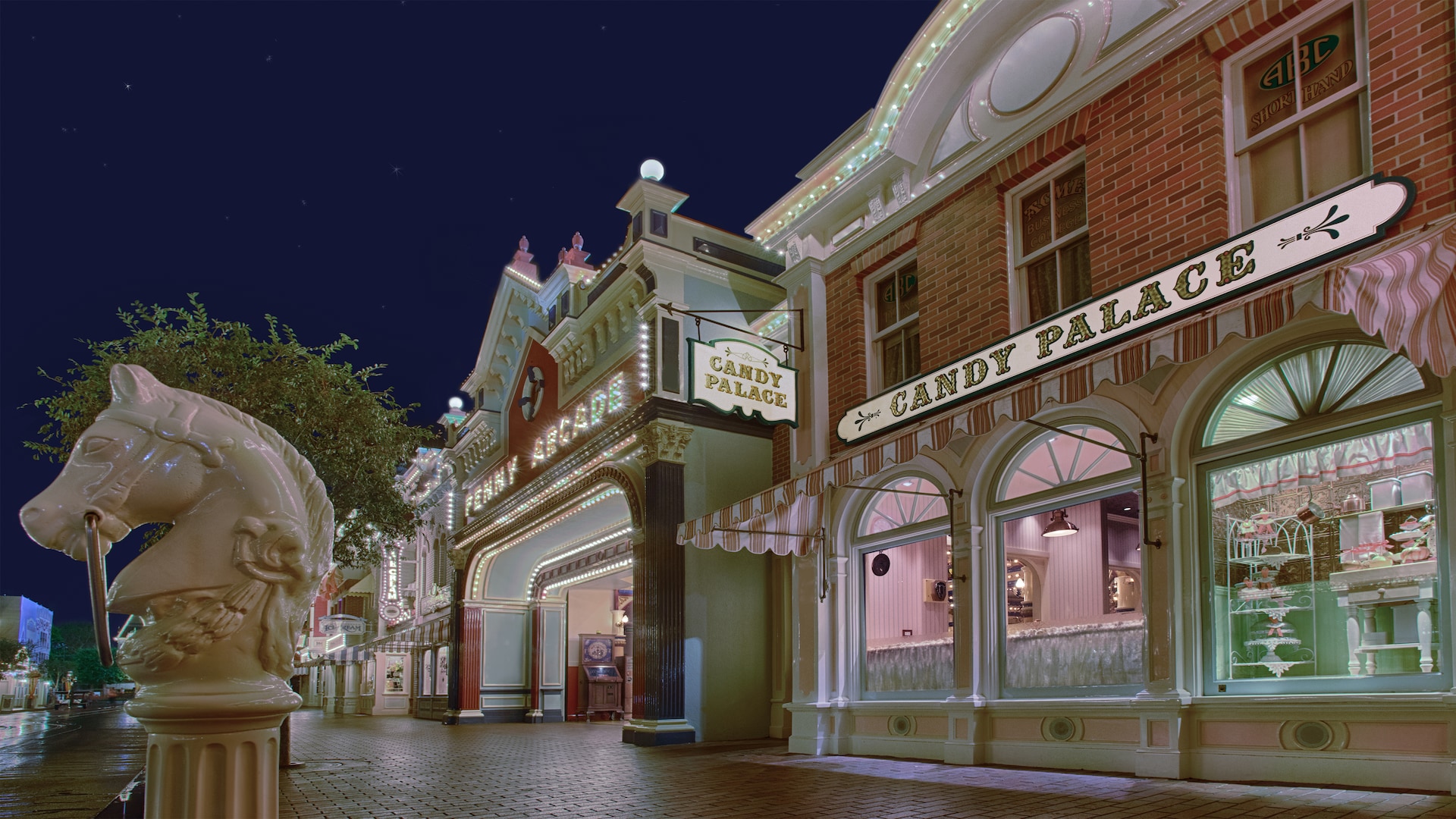 The Candy Palace and Penny Arcade lighting up the night down Main Street, U.S.A. at Disneyland Park