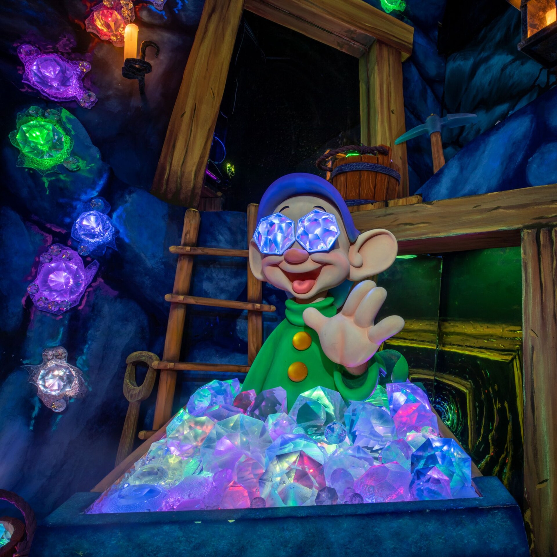 Dopey the Dwarf waves hello from behind a mining car filled with gems in the Snow White’s Enchanted Wish attraction at Disneyland Park in California