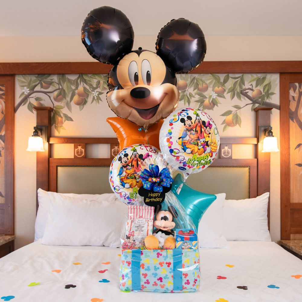 A Mickey Mouse birthday welcome basket on a Disneyland Resort hotel bed