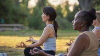 A group of women performing yoga while outdoors