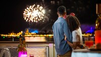 A couple enjoys a fireworks display in Magic Kingdom park