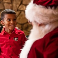 A young boy smiles at Santa Claus
