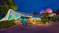 The Seas with Nemo & Friends Pavilion lit up at night, next to a monorail train and Spaceship Earth