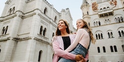 Mother holding daughter amid buildings looking on Mother holding daughter amid buildings looking on