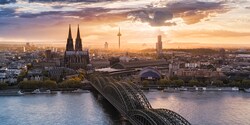A city featuring a church with spires, skyscrapers and a covered bridge that spans the Rhine River A city featuring a church with spires, skyscrapers and a covered bridge that spans the Rhine River