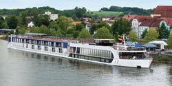 A modern ferry flying the German flag stops at a port in front of green, rolling hills A modern ferry flying the German flag stops at a port in front of green, rolling hills