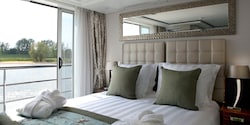 A Category AB room, featuring a double bed and a sliding balcony door. A Category AB room, featuring a double bed and a sliding balcony door.