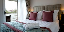 A Category BB room, featuring a double bed and a table with chairs, outside of a sliding balcony door. A Category BB room, featuring a double bed and a table with chairs, outside of a sliding balcony door.