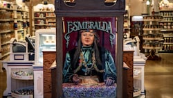 A fortune telling machine features a stern looking woman in flashy clothing named Esmeralda