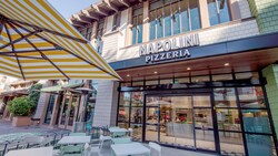 The front entrance to Napolini Pizzeria features patio dining space