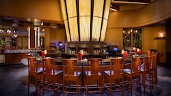 Un elegante bar circular con sillas de respaldo alto en Napa Rose Lounge