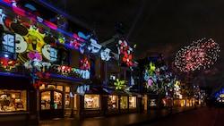 Projected images of Mickey Mouse and Minnie Mouse on Crystal Arcade with fireworks in the background