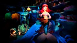 An Audio-Animatronics figure of Ariel looks through a small treasure chest