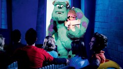 Guests ride through Monstropolis in a taxi and pass Sully holding Boo close