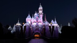 The façade of Sleeping Beauty Castle decorated with icicle lights and illuminated at night