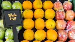 A fruit stand with apples and oranges