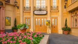 A sign reading ‘Impressions de France’ hangs over a door in a courtyard