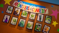 Framed pictures of the Monsters of Comedy on a wall at the Monsters, Inc. Laugh Floor attraction