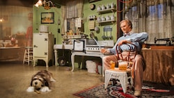 An Audio-Animatronic man and dog sit in a house with the latest conveniences of the 1920s