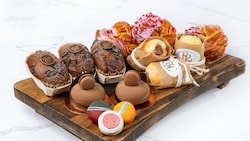 A tray with Banana Bread, Raspberry Brioche, Hazelnut-Chocolate Bomboloni and Trois Chocolat pastries