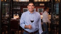 Master Sommelier George Miliotes holding a glass of wine