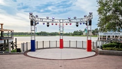 A circular stage in front of the lake at Waterview Park, framed by overhead lighting