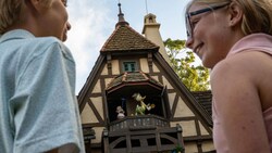 Two children smiling at each other while standing in the Norway Pavilion at Epcot