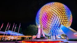The prism pylon fountain in front of an illuminated Spaceship Earth at Epcot.