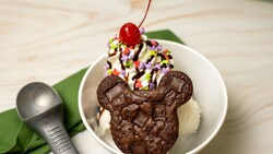 A Mickey Brownie Sundae from Hollywood Scoops topped with whipped cream, a cherry and a Mickey Mouse shaped brownie