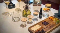 A tequila tasting flight with labeled glasses, garnishes and a wooden pairing board 