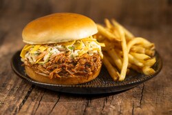 The Coca Cola Cherry Braised Pork Sandwich with fries from Pecos Bill Tall Tale Inn and Cafe