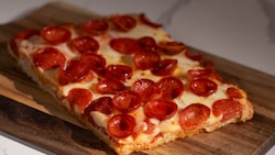 A slice of Sicilian style pepperoni pizza