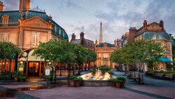 A courtyard at the France Pavilion at Epcot, featuring trees, a fountain and a replica of the Eiffel Tower