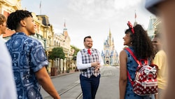 A VIP Tour Guide and Guests walking down Main Street, USA with Cinderella Castle in the distance
