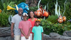A family of four pose for a picture outside of The Seas with Nemo and Friends