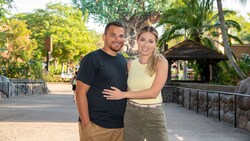 Two people pose for a picture in front of the Tree of Life