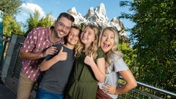 A family of 4 smile on a bridge near Mount Everest